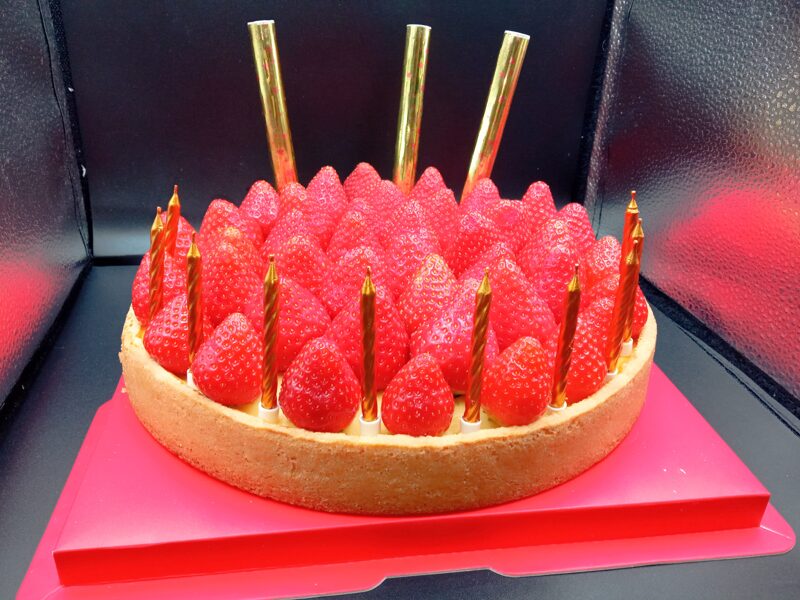 Cheesecake with Fresh Strawberries and Candles in Gift Box and Cardboard Bag